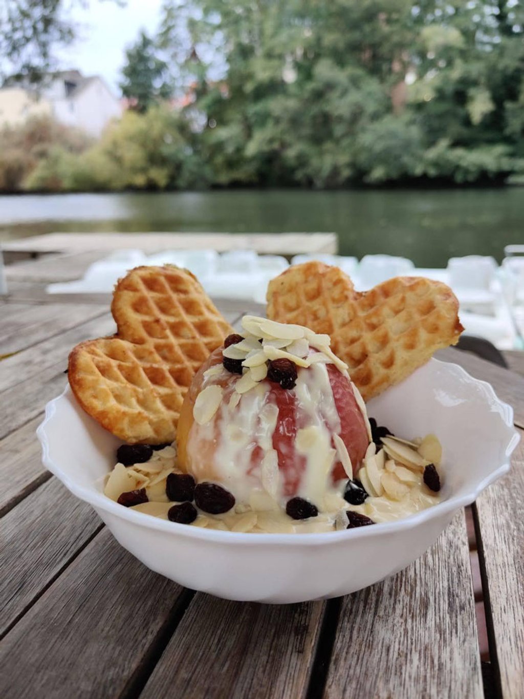 Herzwaffeln mit Eis, Mandeln und Beerensauce am Fluss