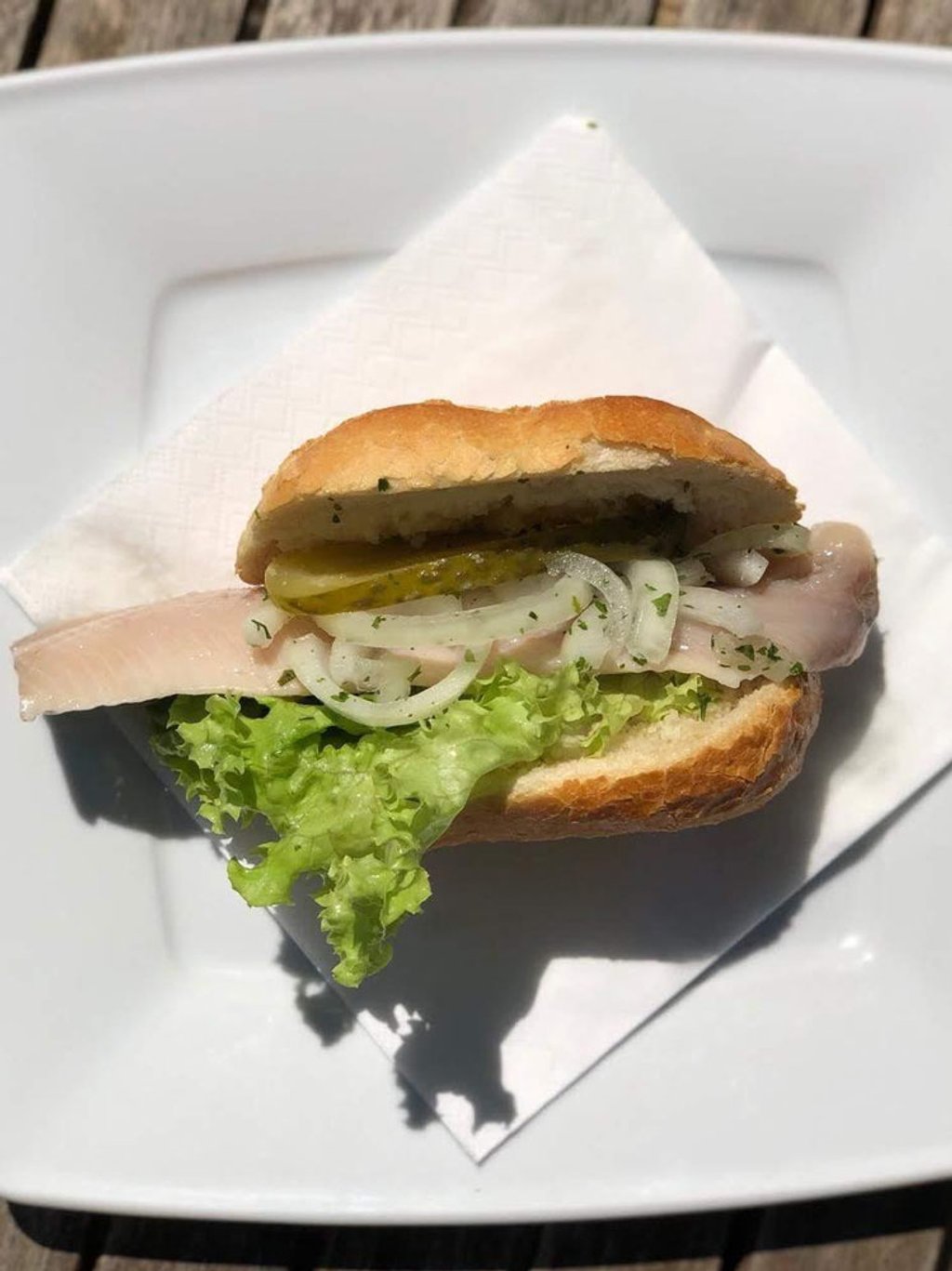 Fischbrötchen mit Salat, Zwiebeln und Gewürzgurke