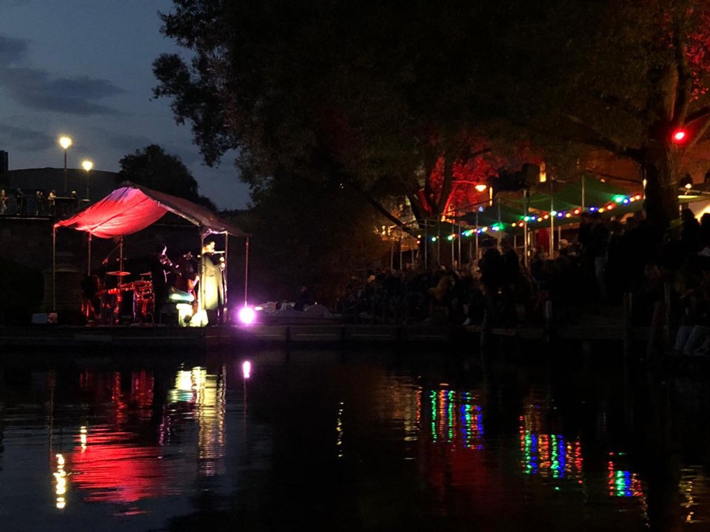 Musiker auf der schwimmenden Bühne mit bunten Lichtreflexionen